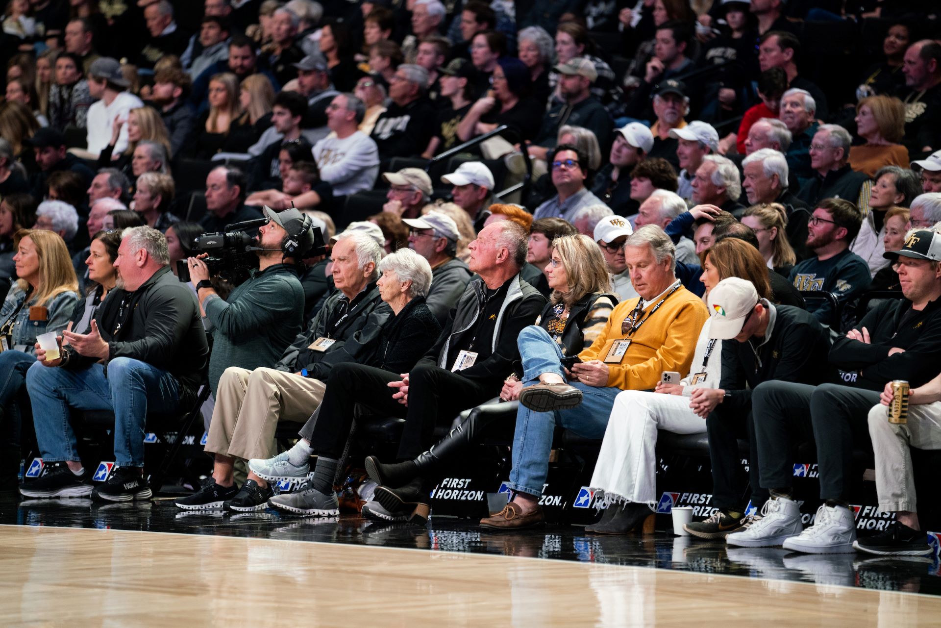 Fans sitting courtside cheering on the Deacs